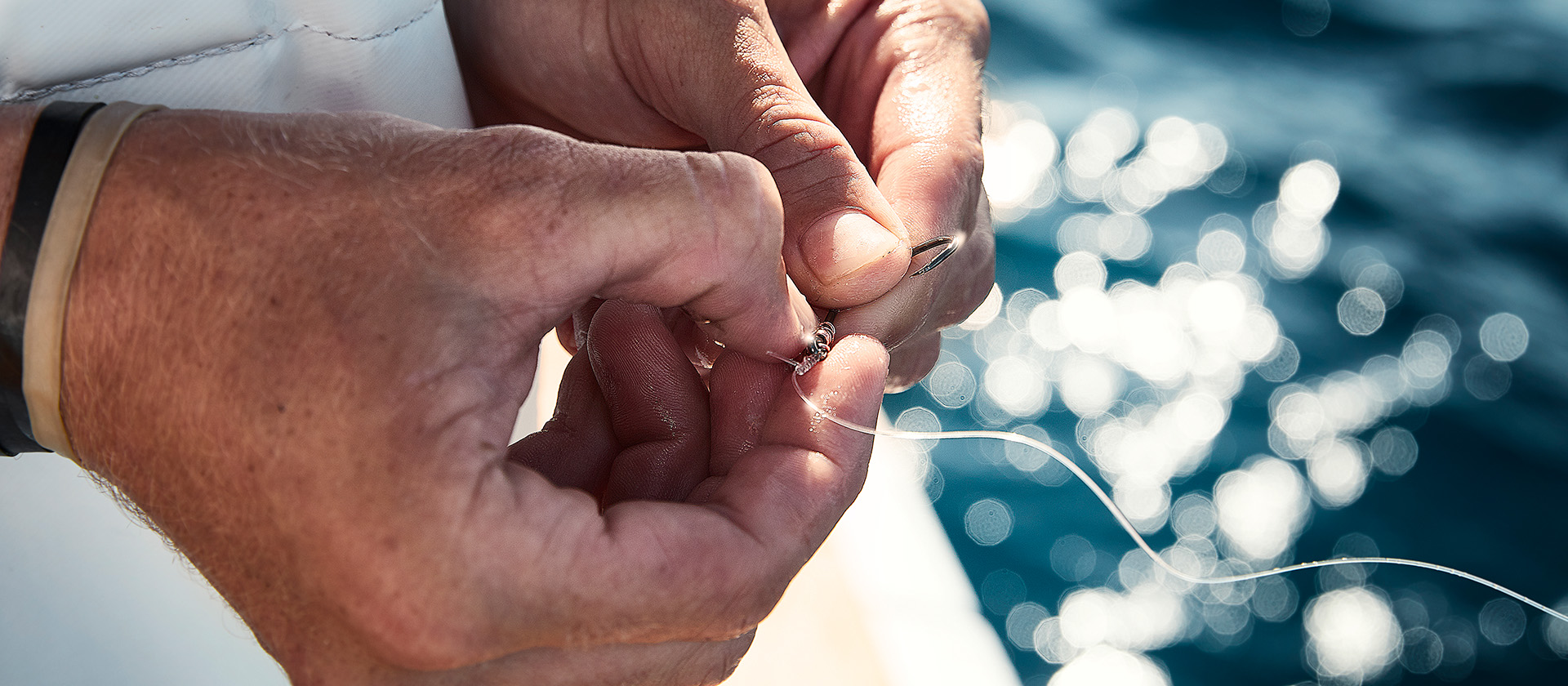 Photo of hands working on a fish hook