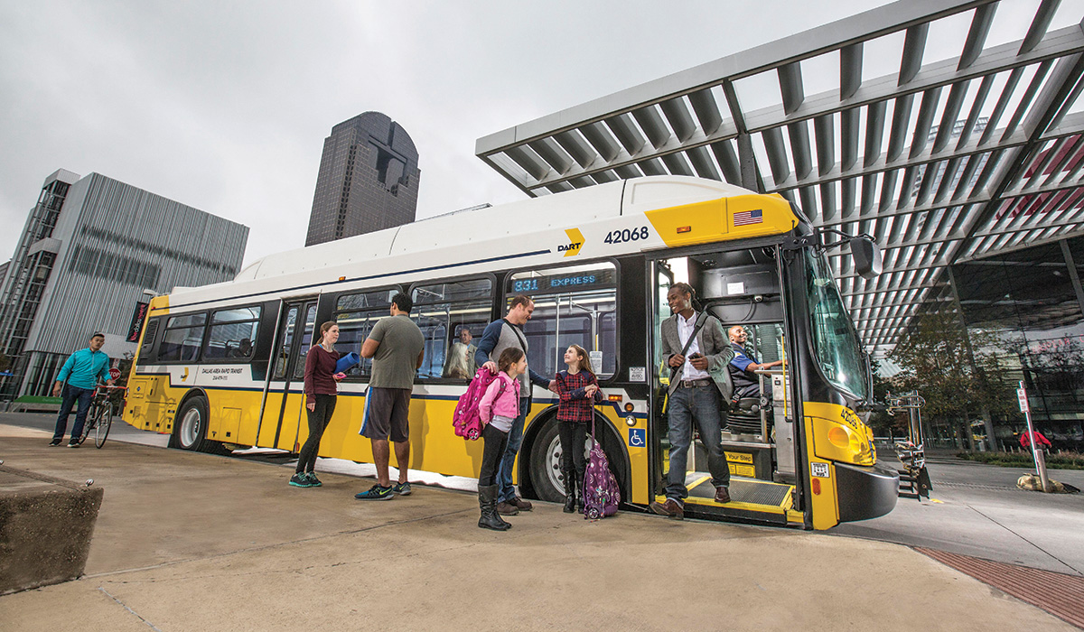 Photo of people getting off a parked hybrid transit bus